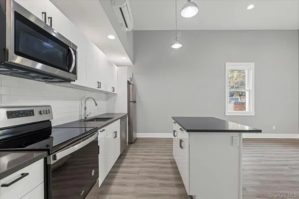 a kitchen with stainless steel appliances granite countertop a sink and a microwave