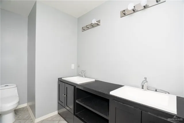 a bathroom with a sink a toilet and a mirror