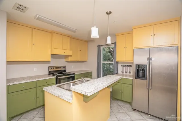 a kitchen with a sink a refrigerator and cabinets