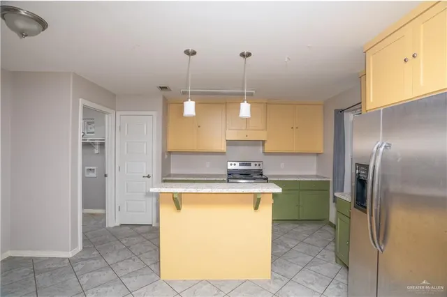 a kitchen with a sink a refrigerator and cabinets