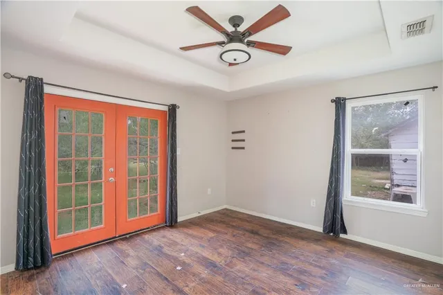 an empty room with wooden floor and windows