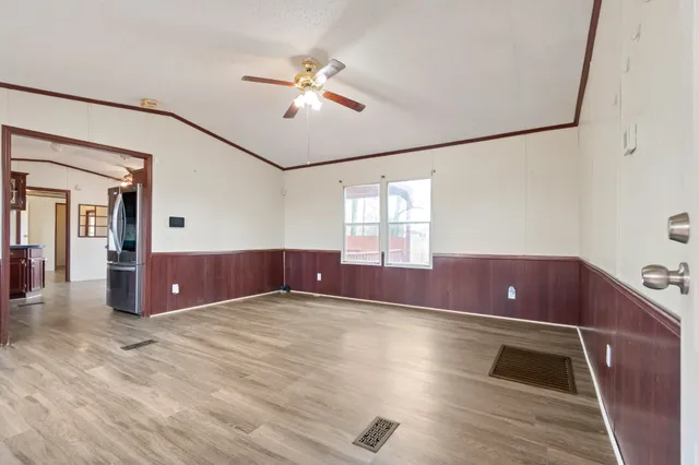 a view of empty room with wooden floor