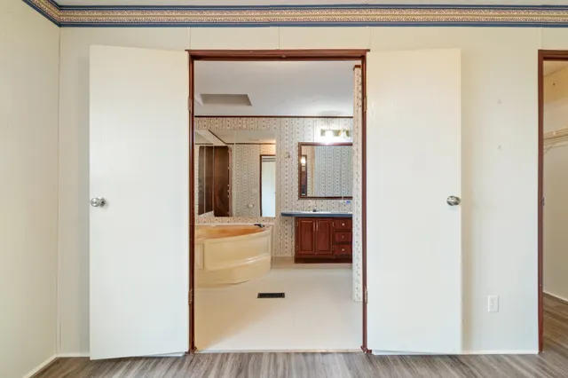 a bathroom with a tub shower sink and mirror