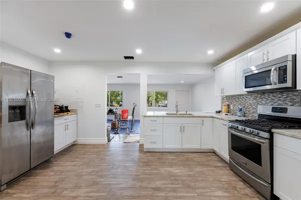 a kitchen with stainless steel appliances granite countertop a stove and a sink