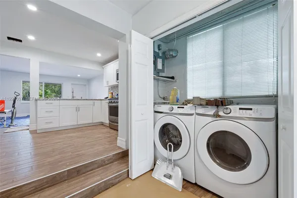 a view of a kitchen with a sink and a washer dryer