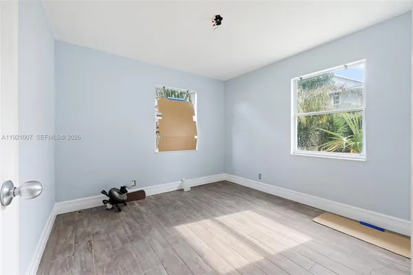 an empty room with a wooden floor and a window