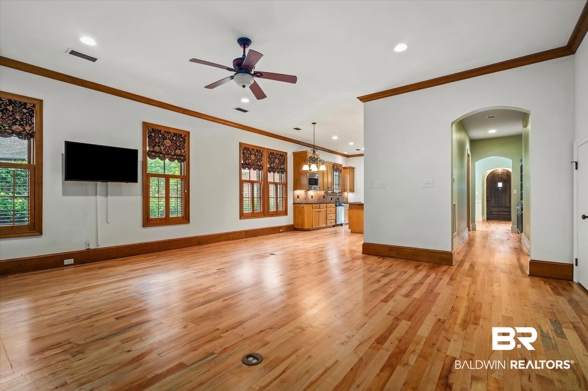 812 Country Club Court Mobile, AL 36609 - Photo 8 of 34 Unfurnished living room featuring ceiling fan with notable chandelier, ornamental molding, and light hardwood / wood-style flooring