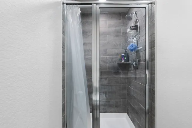 a bedroom with a bed desk and a window