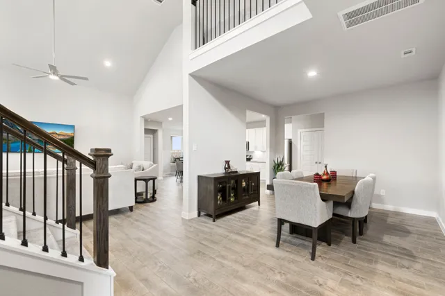 a kitchen with kitchen island granite countertop a stove top oven a sink dishwasher a dining table and chairs with wooden floor