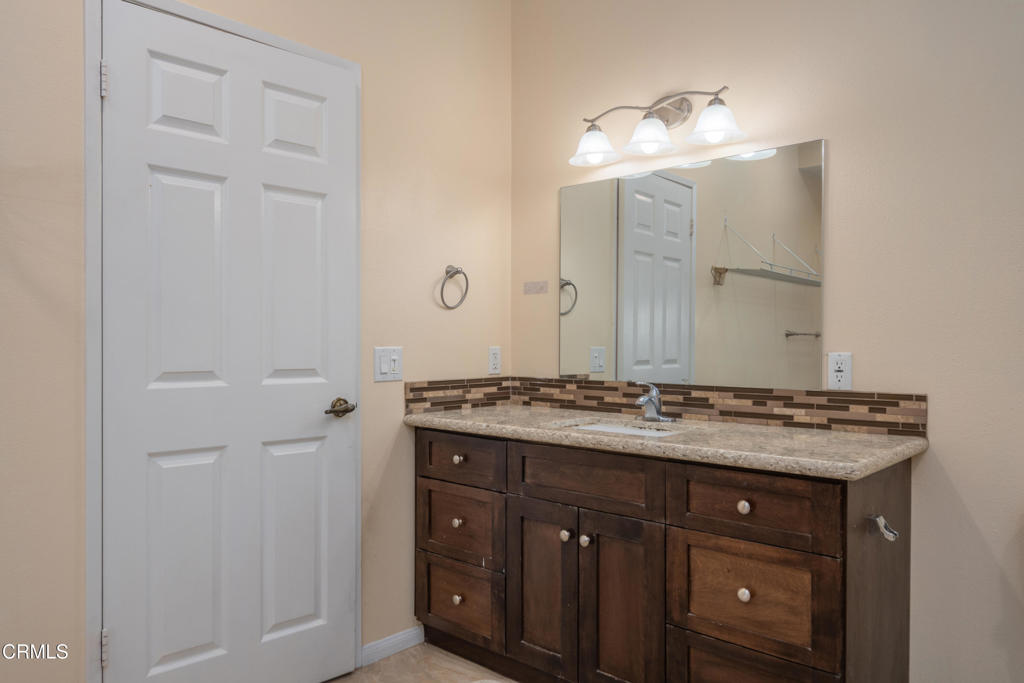 670 Joliet Place Oxnard, CA 93030 - Photo 17 of 33 a bathroom with a granite countertop sink a mirror and a shower