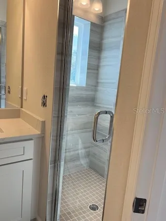 a bathroom with a granite countertop shower and a sink
