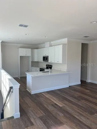a view of kitchen with wooden floor and electronic appliances