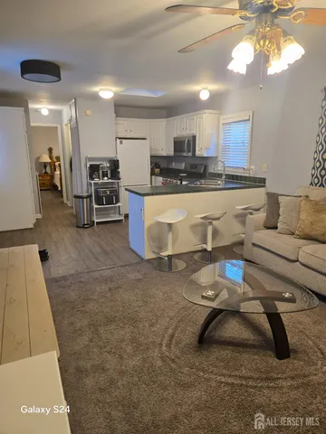 a living room with furniture and kitchen view