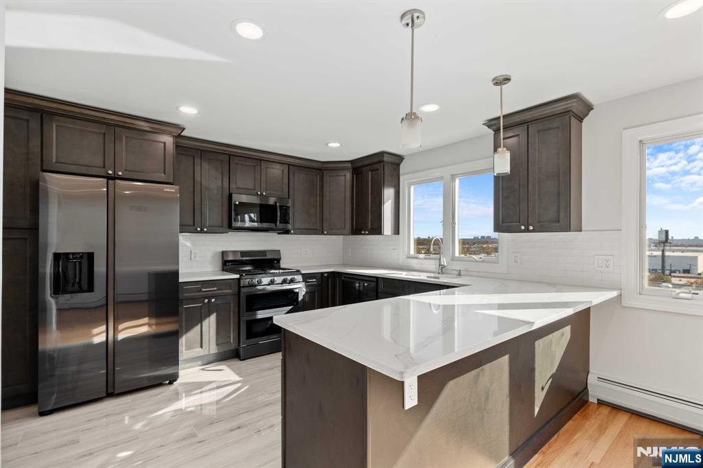 a kitchen with stainless steel appliances granite countertop a sink a stove and a refrigerator