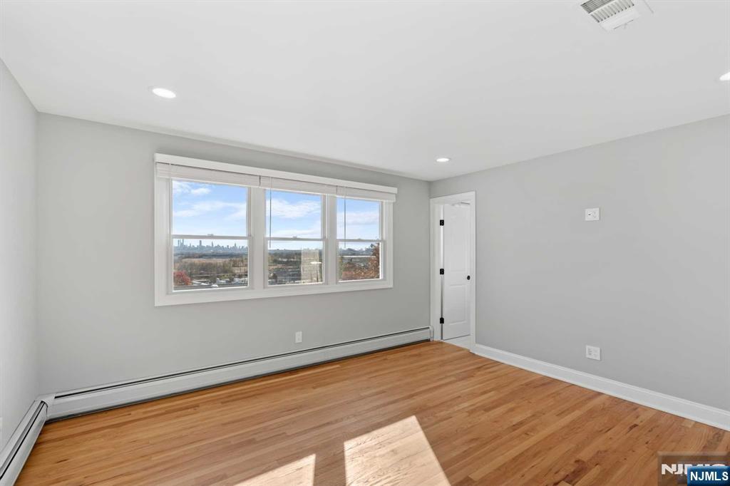 743 7th Street, Unit 1 Carlstadt, NJ 07072 - Photo 11 of 23 an empty room with wooden floor and windows