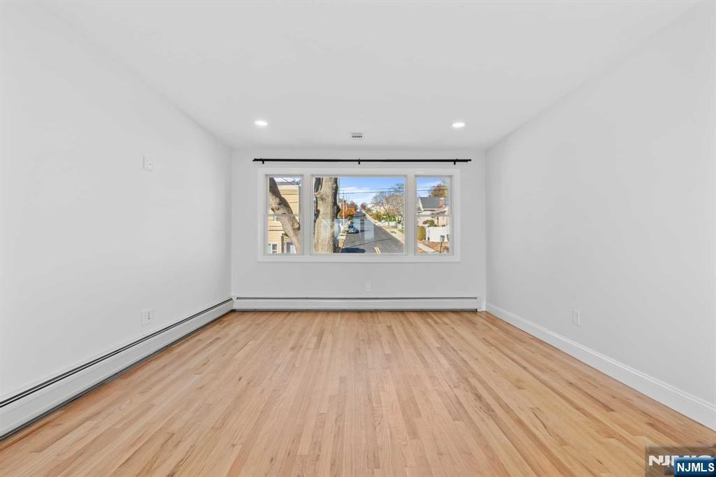 743 7th Street, Unit 1 Carlstadt, NJ 07072 - Photo 18 of 23 a view of an empty room with wooden floor and a window