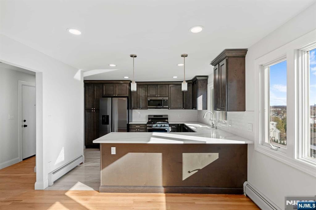 743 7th Street, Unit 1 Carlstadt, NJ 07072 - Photo 2 of 23 a kitchen with kitchen island stainless steel appliances a sink counter space and a window