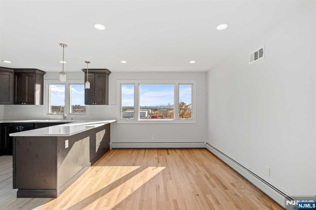 743 7th Street, Unit 1 Carlstadt, NJ 07072 - Photo 7 of 23 a large kitchen with stainless steel appliances a large counter top a stove and a wooden floors