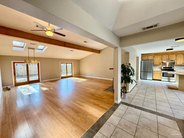 a view of a hallway with wooden floor and a living room