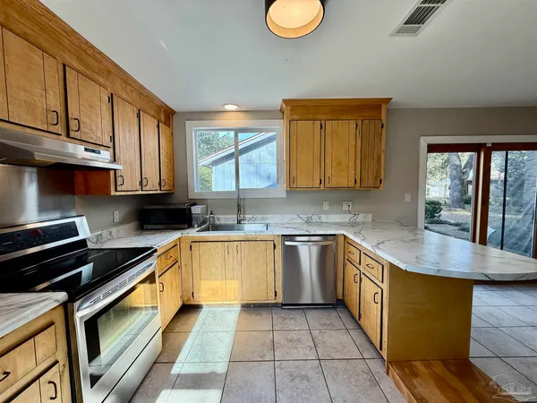 a kitchen with stainless steel appliances granite countertop a sink stove and cabinets