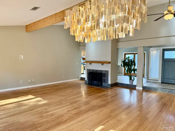 a view of a livingroom with wooden floor and a fireplace