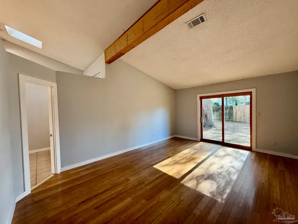 a view of a room with wooden floor and window