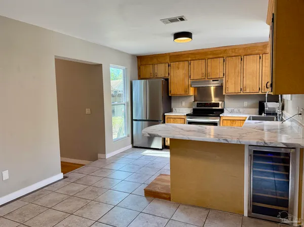 a kitchen with kitchen island granite countertop a stove cabinets and refrigerator