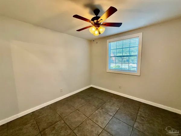 an empty room with window and ceiling fan