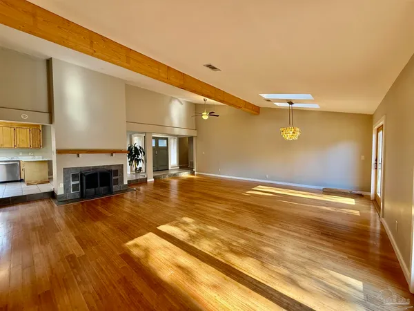 a view of empty room with wooden floor and fireplace
