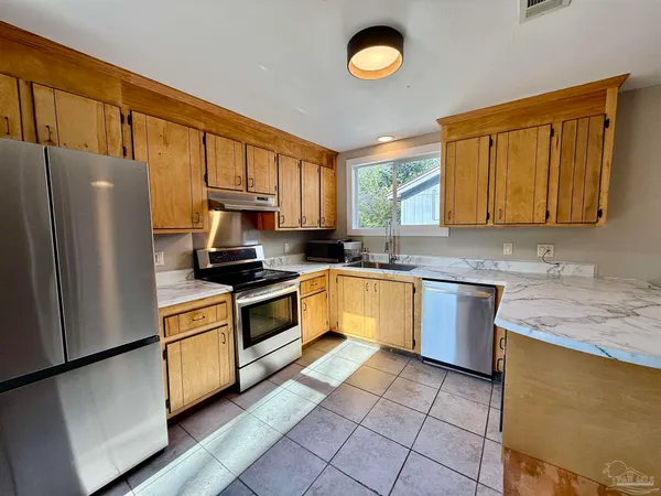 a kitchen with stainless steel appliances granite countertop a stove sink and cabinets