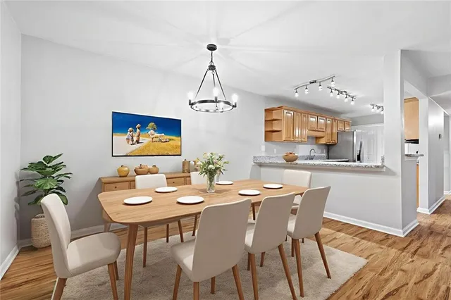 a dining room with furniture a chandelier and wooden floor