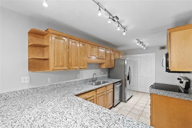 a kitchen with stainless steel appliances granite countertop a sink stove and cabinets