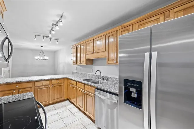 a kitchen with a sink refrigerator and cabinets