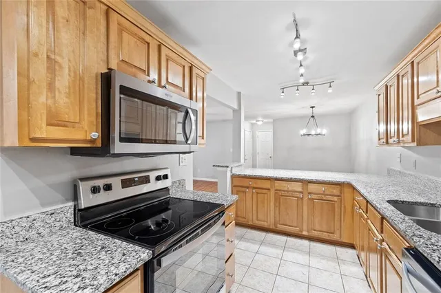 a kitchen with stainless steel appliances granite countertop a stove a sink and a microwave
