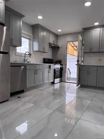 a kitchen with stainless steel appliances granite countertop a sink stove and refrigerator