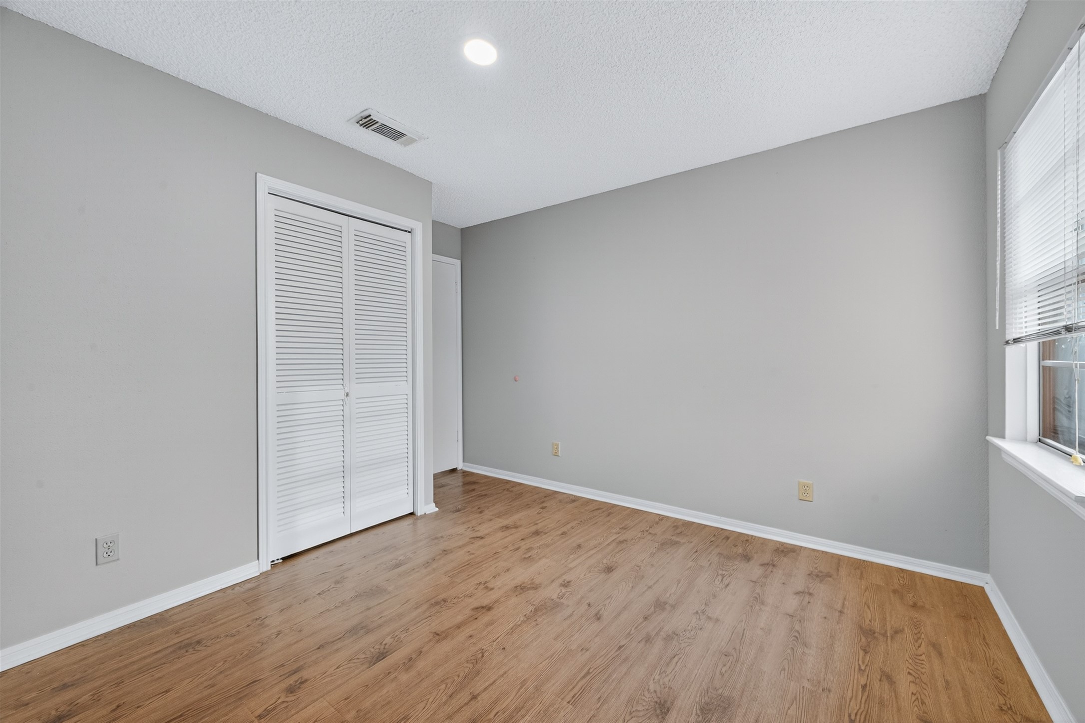 1445 Bonanza Road, Unit 445 Houston, TX 77062 - Photo 27 of 34 an empty room with wooden floor and windows