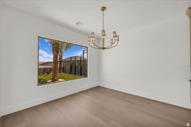 1620 Belayer Drive St. George, UT 84770 - Photo 16 of 51 Spacious room featuring wood-finish flooring, a large picture window, and a contemporary brass chandelier