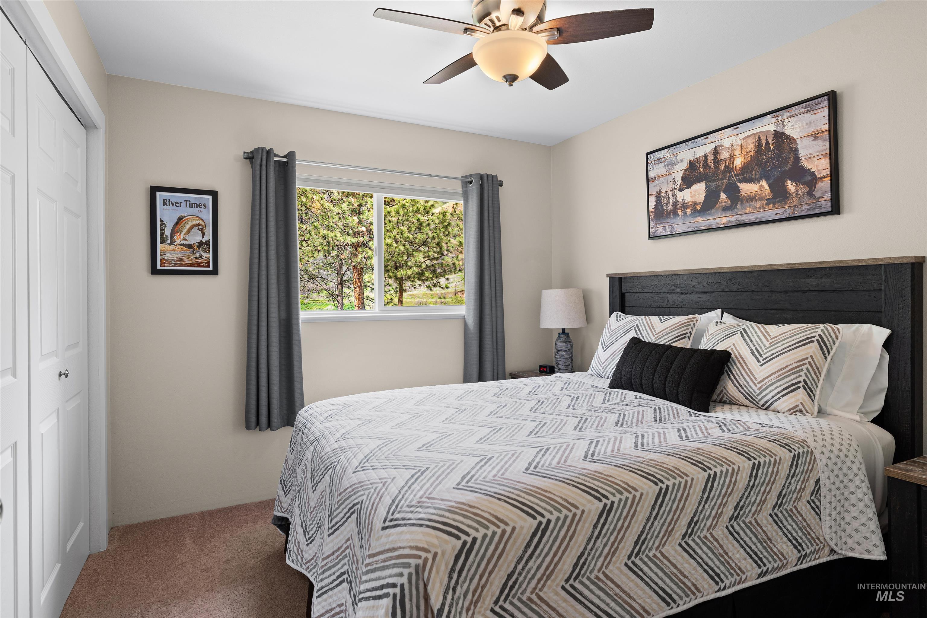 20015 Clark Street Juliaetta, ID 83535 - Photo 18 of 46 Bedroom featuring a window with exterior tree scenery, soft beige wall paint, a ceiling fan with integrated lighting.