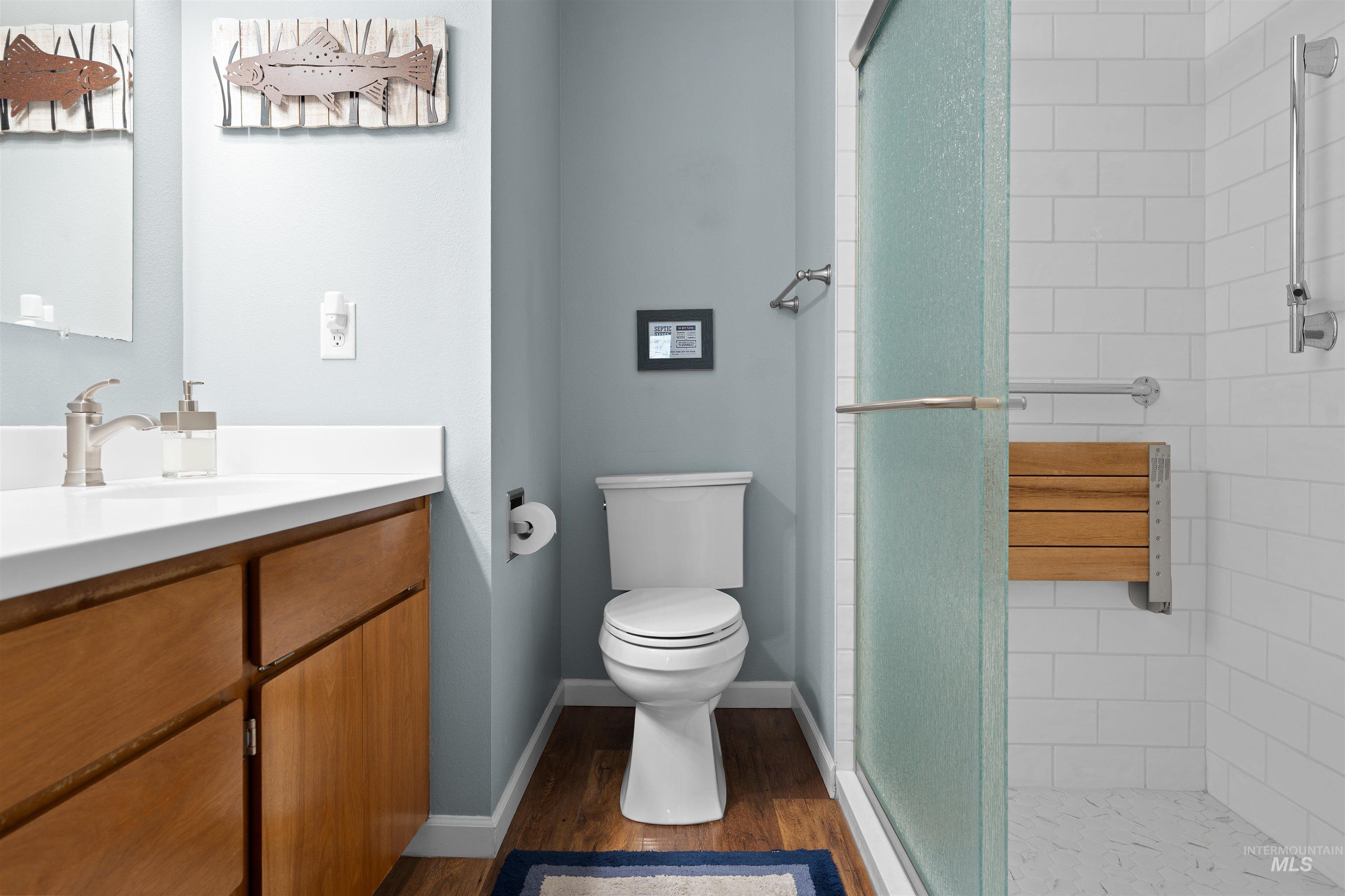 20015 Clark Street Juliaetta, ID 83535 - Photo 22 of 46 Full bathroom featuring a walk-in shower with a frosted glass door, white subway tile surround, and a built-in wooden bench