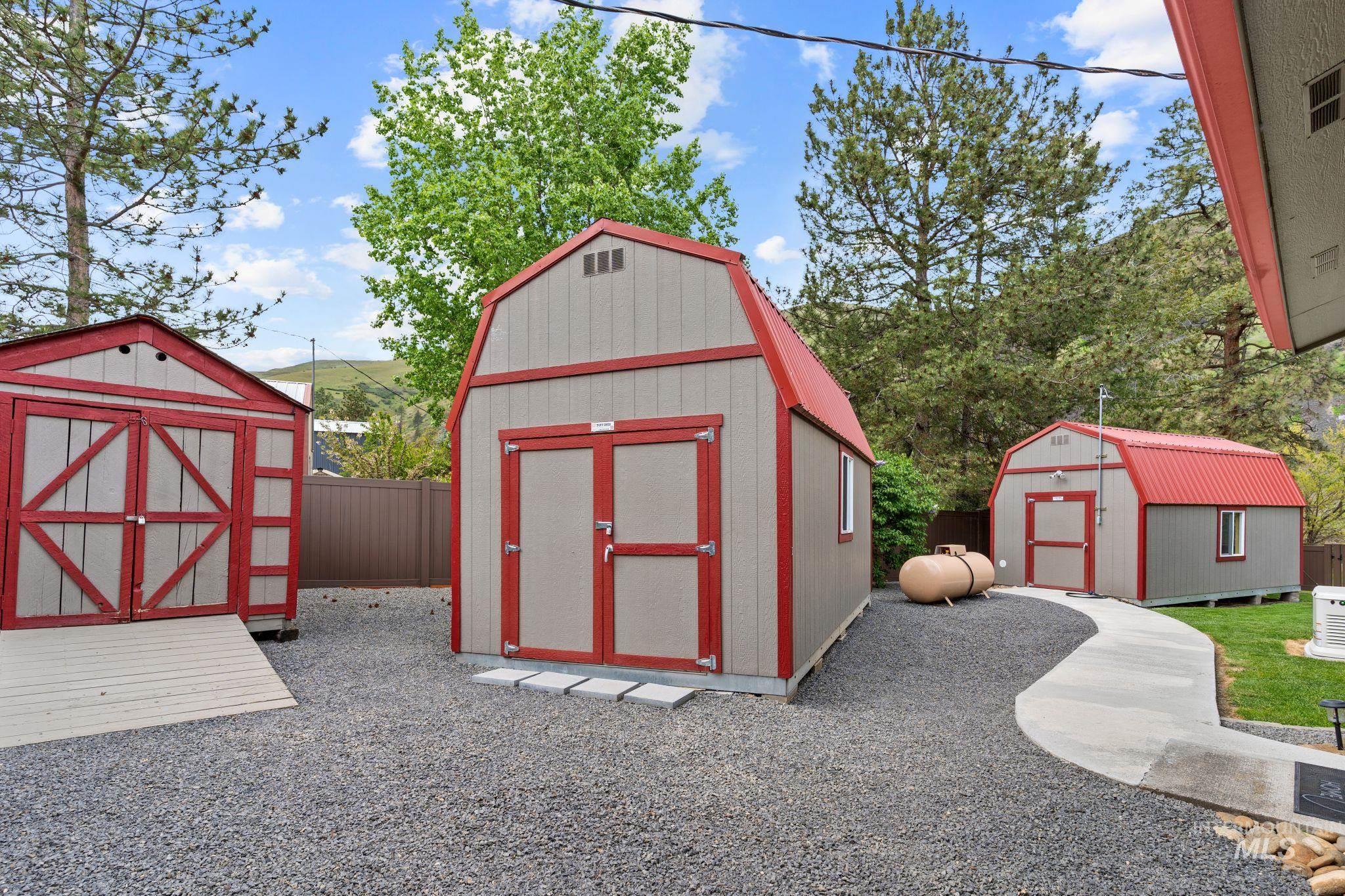 20015 Clark Street Juliaetta, ID 83535 - Photo 24 of 46 Three exterior storage sheds featuring red metal roofs and light gray siding