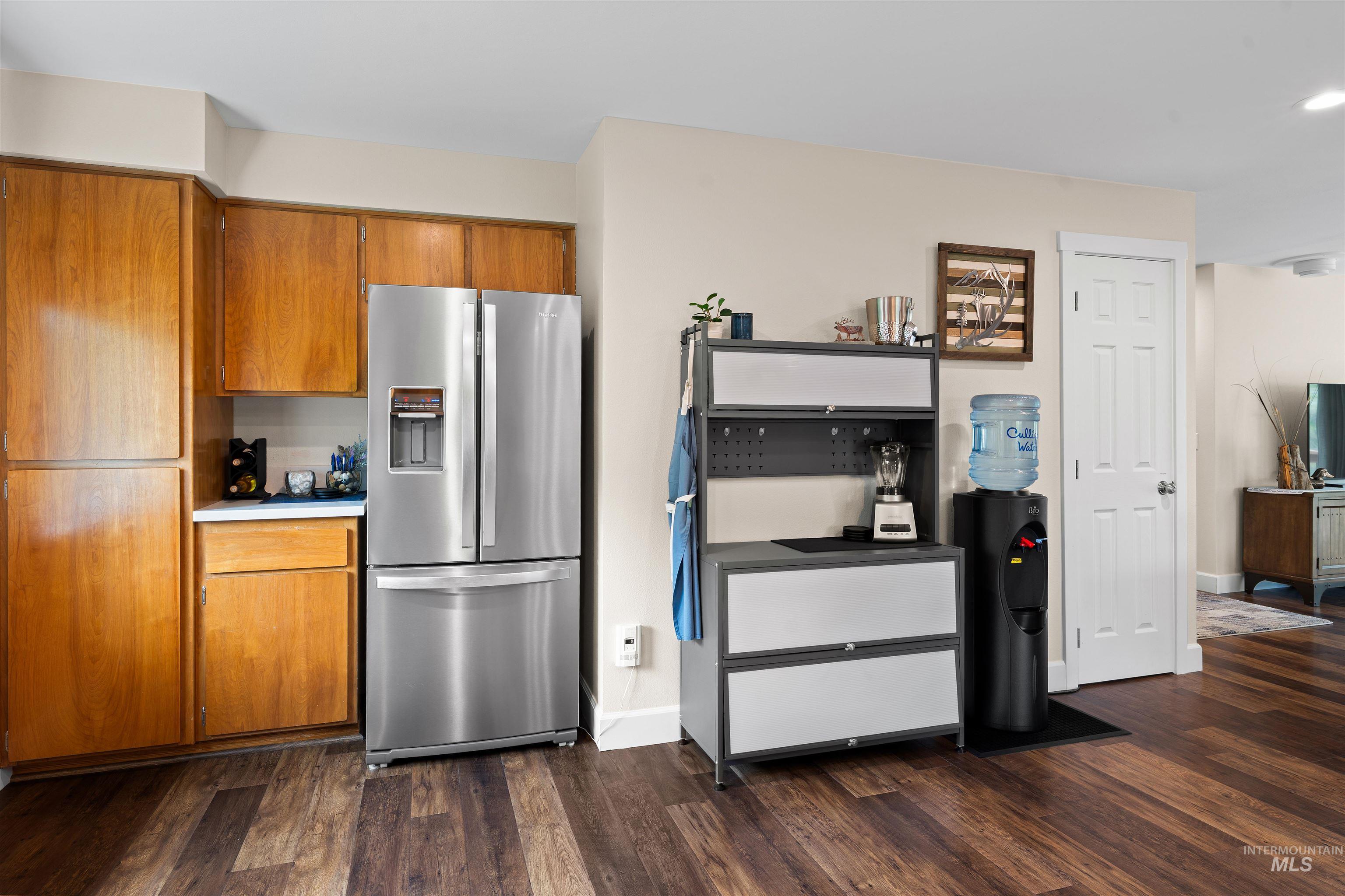 20015 Clark Street Juliaetta, ID 83535 - Photo 31 of 46 Kitchen area featuring wood-finish flooring, ample cabinetry with a light wood finish, a stainless steel refrigerator, and light-toned walls