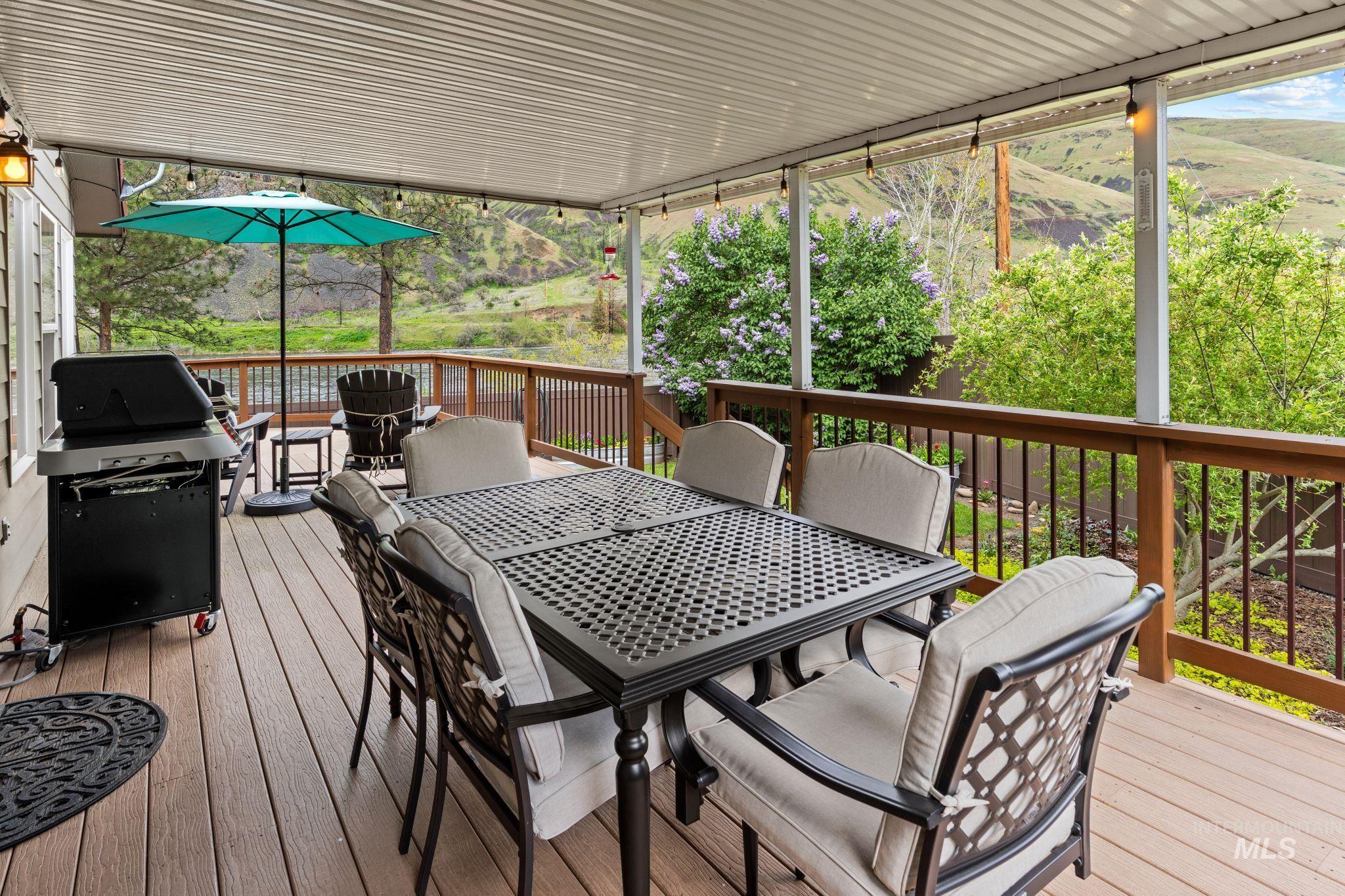 20015 Clark Street Juliaetta, ID 83535 - Photo 39 of 46 Expansive covered deck featuring composite wood-finish flooring, a wood and metal railing system, and string lighting