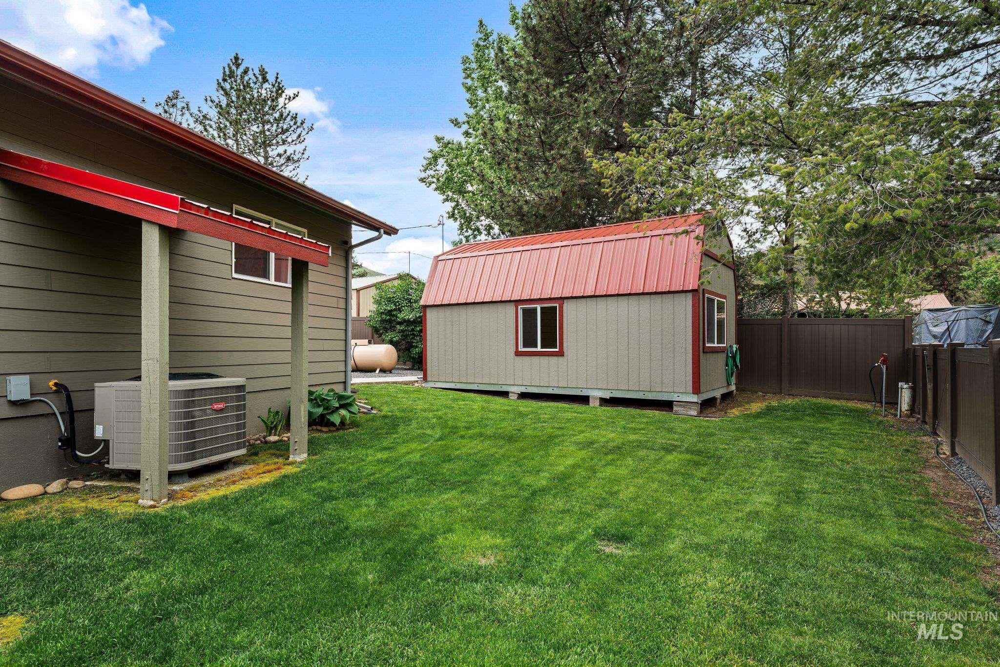 20015 Clark Street Juliaetta, ID 83535 - Photo 42 of 46 Expansive green lawn with a detached storage shed featuring a red metal roof and two windows