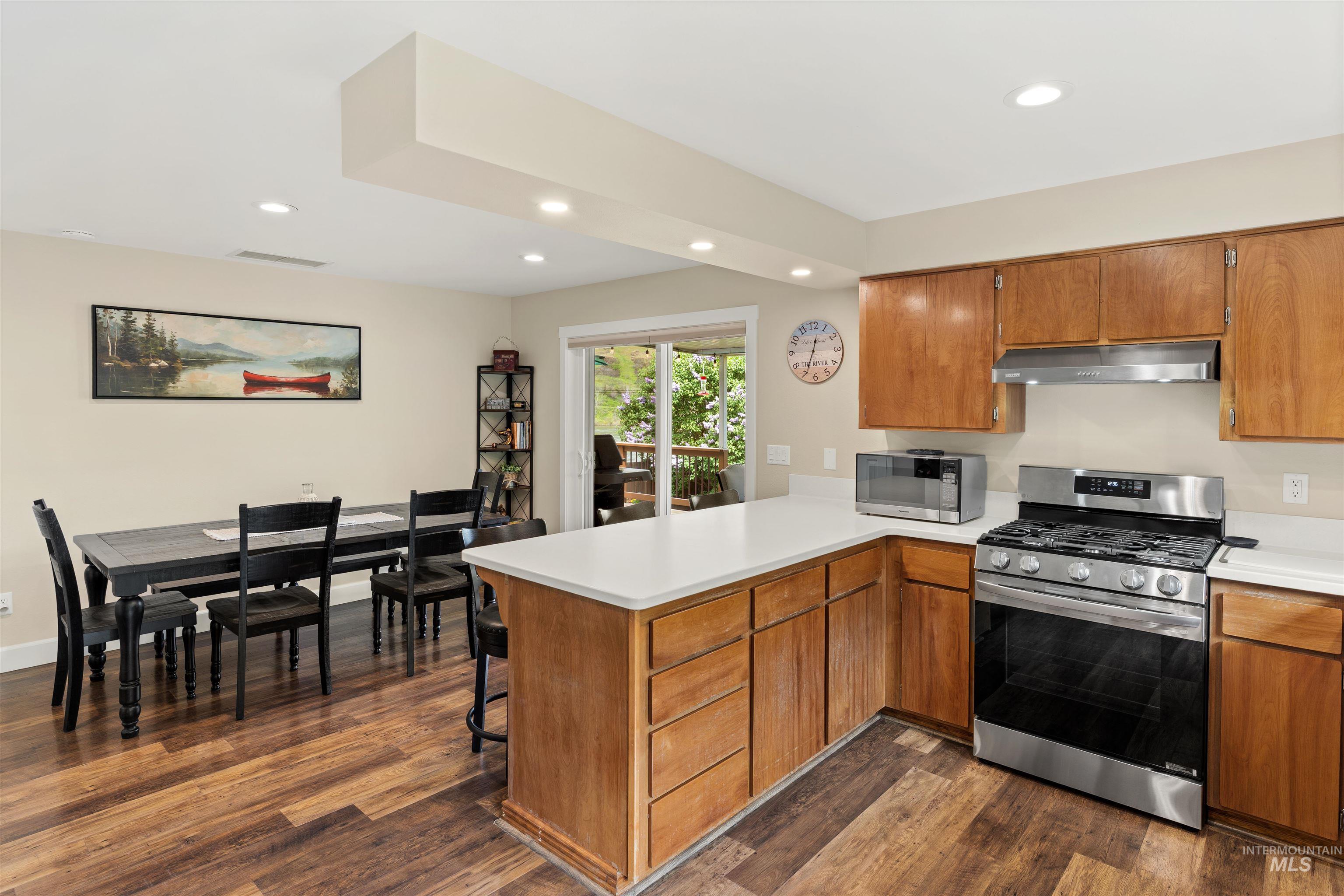 20015 Clark Street Juliaetta, ID 83535 - Photo 10 of 46 Open-concept kitchen and dining area featuring wood-finish flooring, recessed lighting, wood cabinetry, and stainless steel appliances