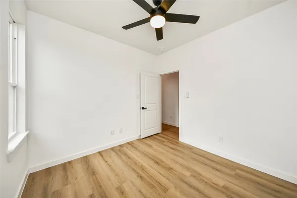 a view of an empty room with wooden floor