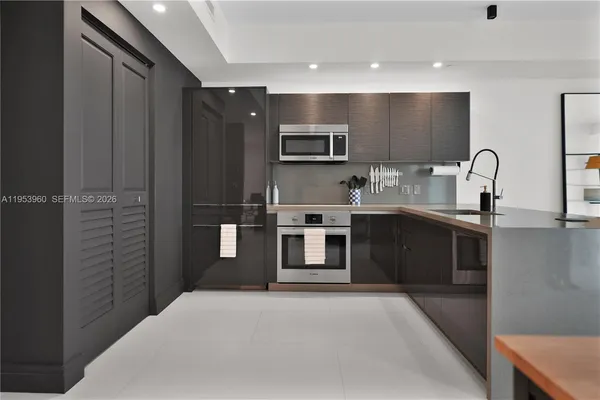 a kitchen with stainless steel appliances kitchen island a sink and refrigerator