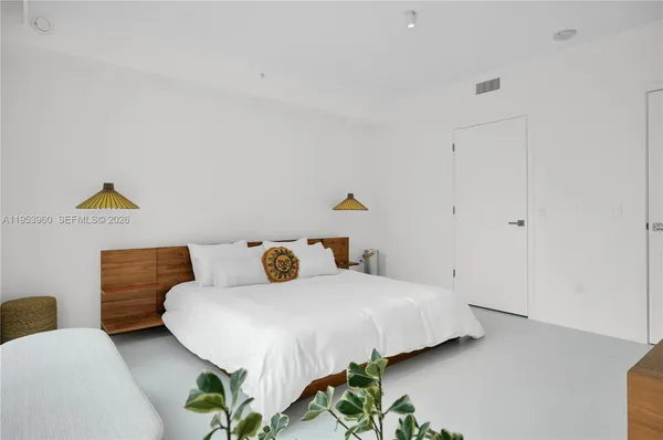 a bedroom with a bed and a potted plant