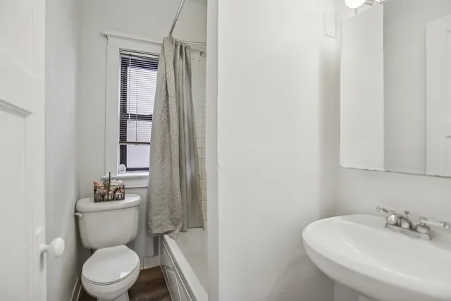 a bathroom with a toilet a sink and mirror