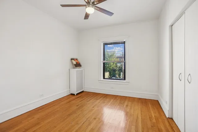 an empty room with a window and wooden floor