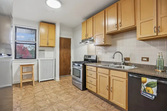 a kitchen with stainless steel appliances granite countertop a refrigerator and a stove top oven
